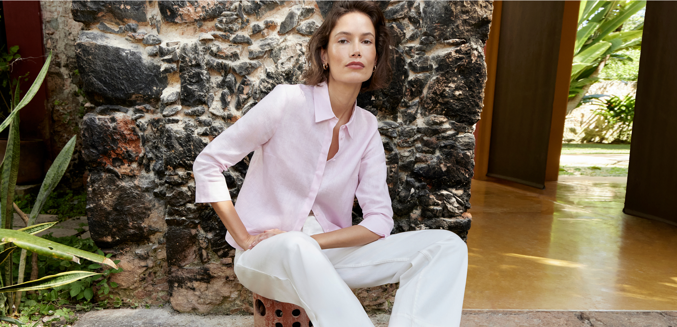 A woman wearing a Hobbs linen shirt and white jeans.
