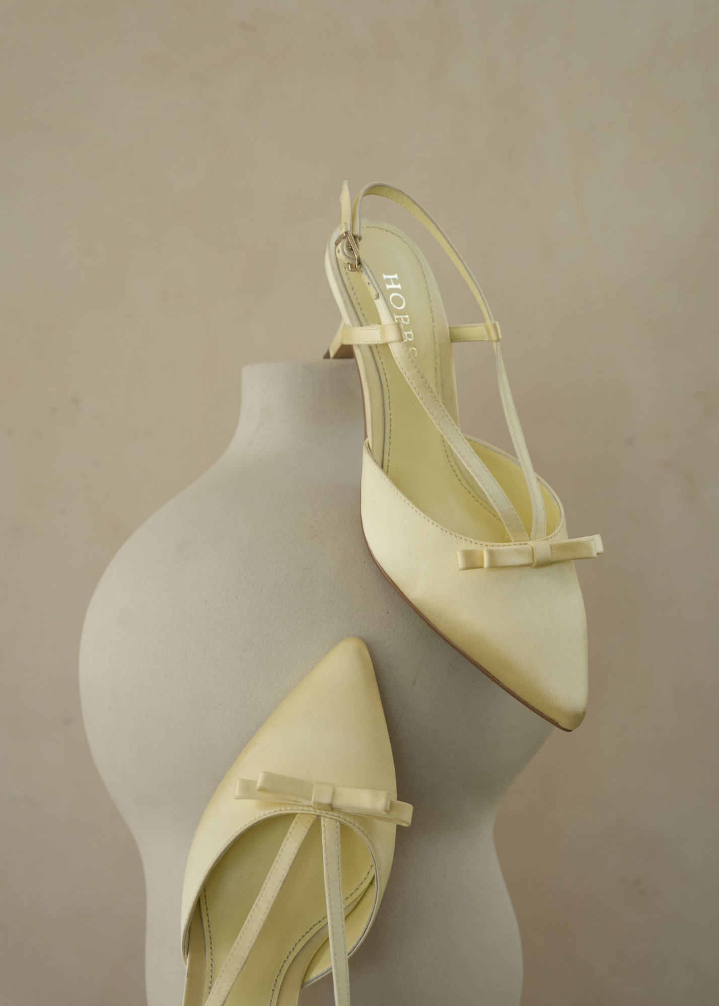 A buttermilk Hobbs satin bag and matching buttermilk Hobbs satin shoes.