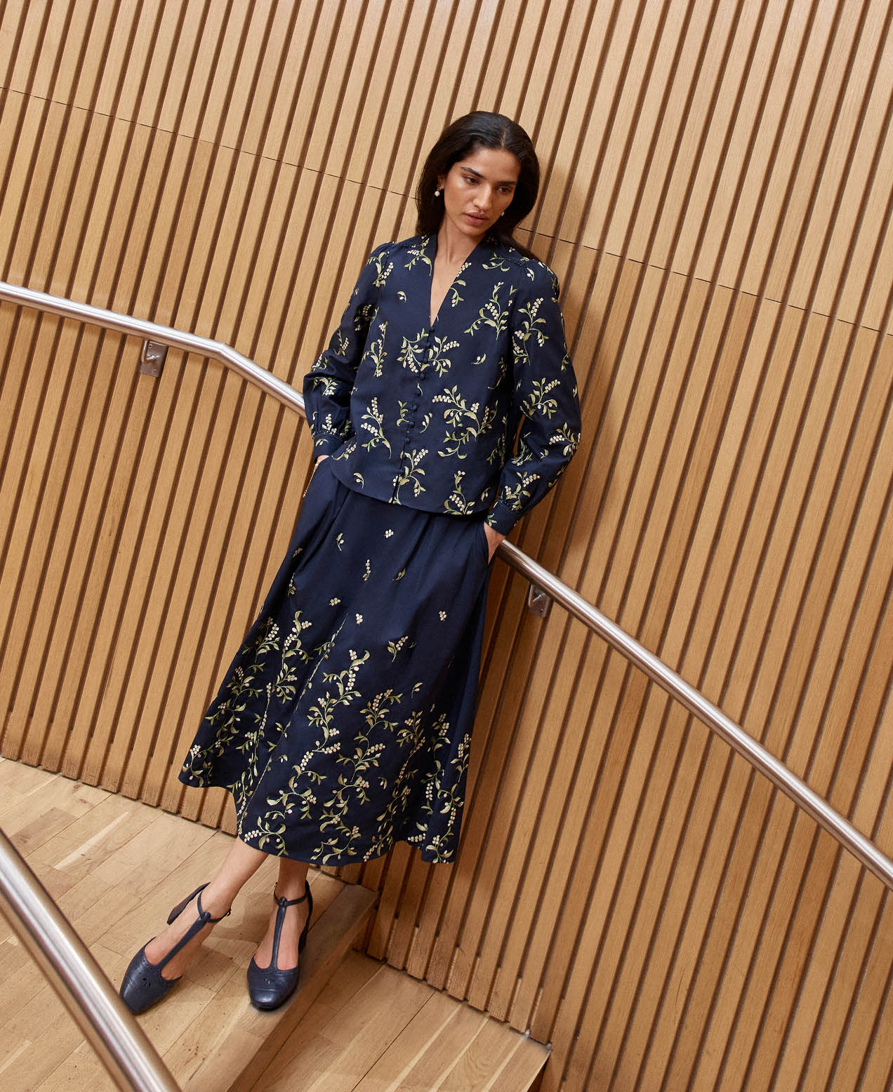 A woman wearing an embroidered navy two piece.