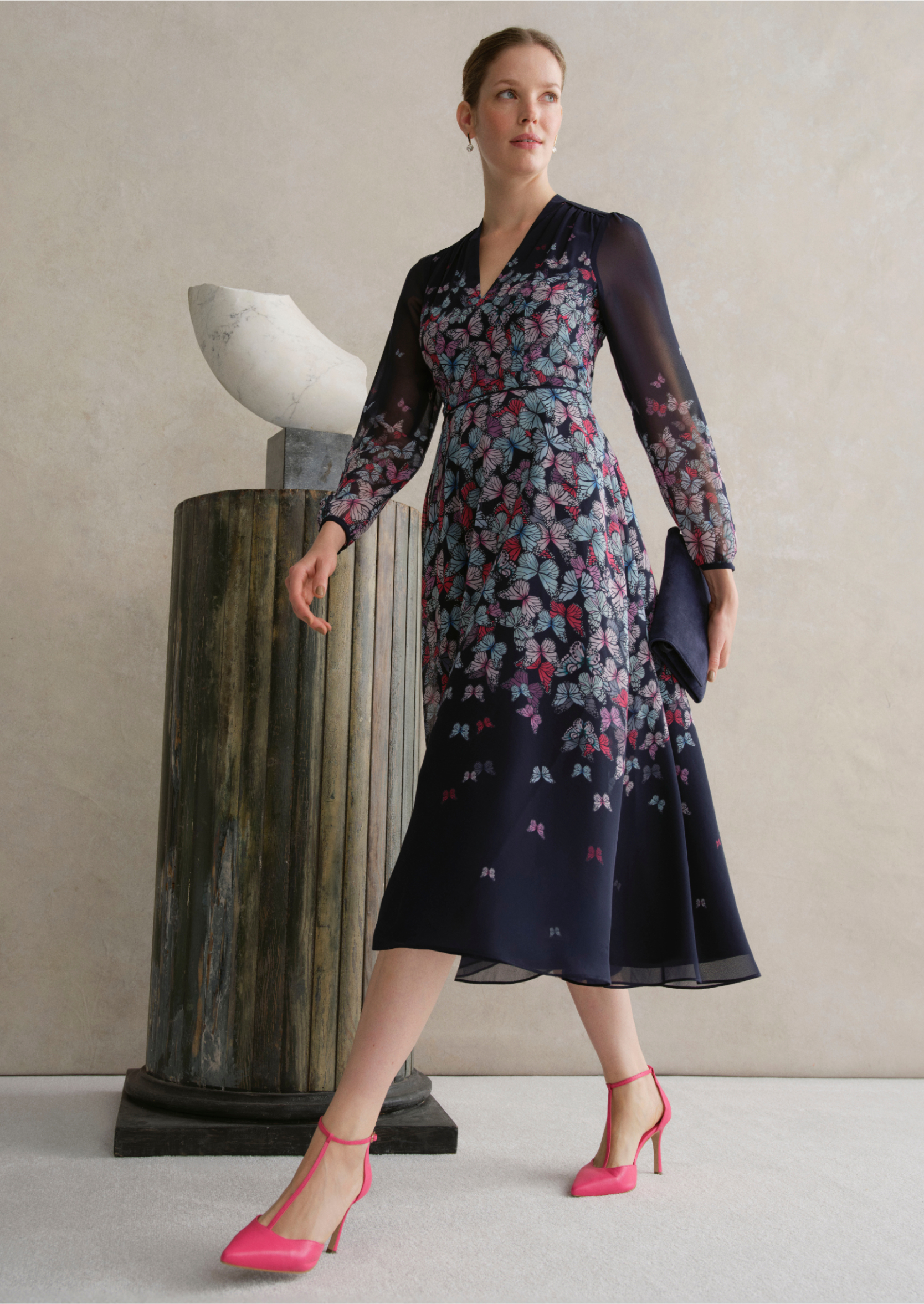 An image of a model wearing a navy occasion floral dress.