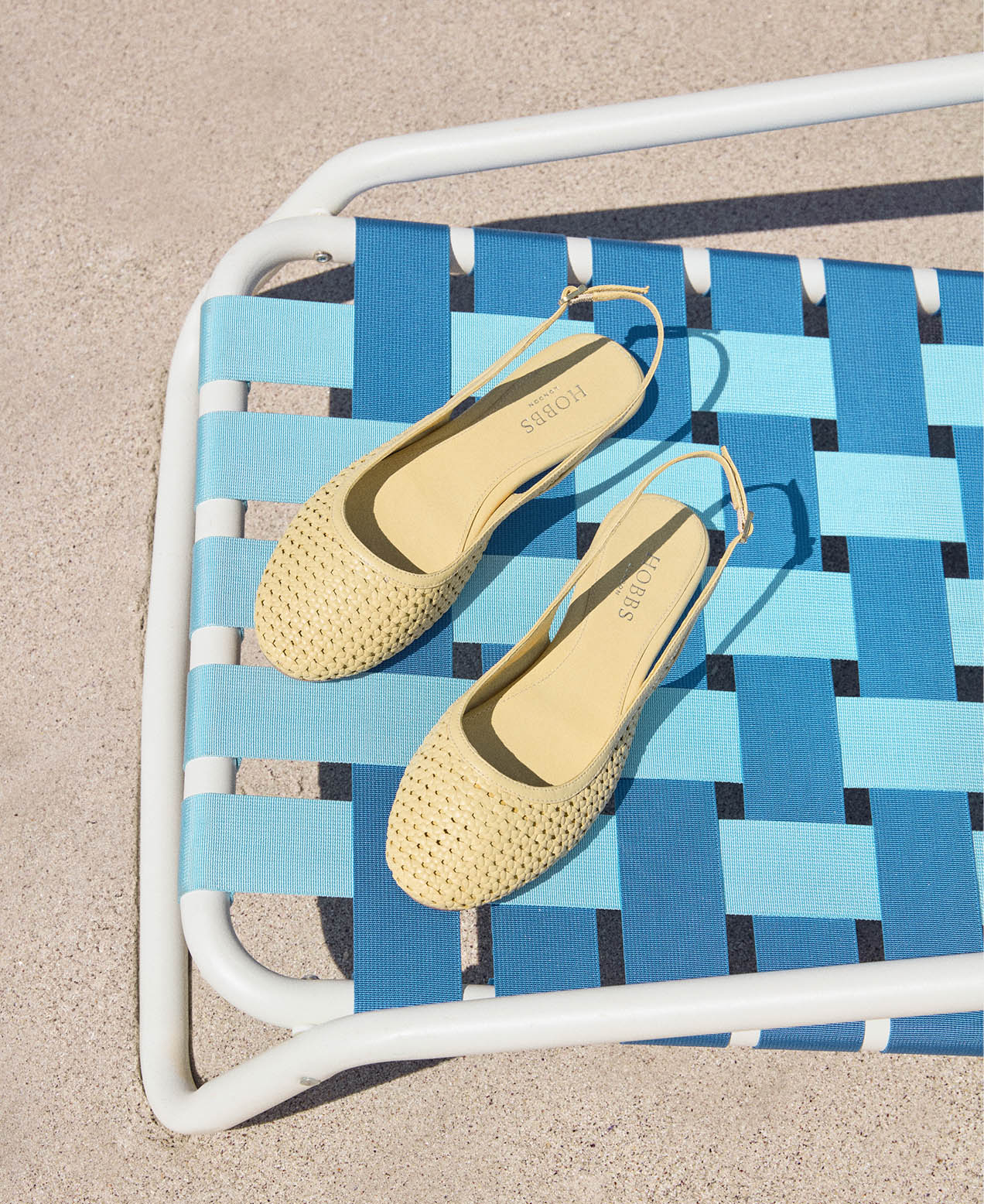 An image of Hobbs’ butter yellow sandals and bags