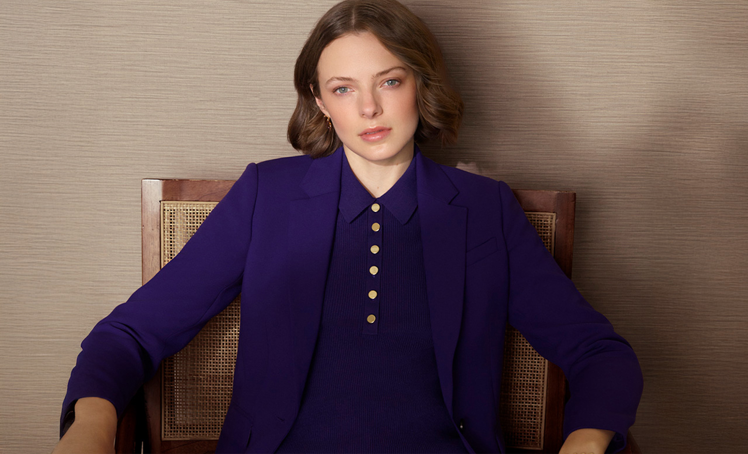 A woman wearing a Hobbs purple collared jumper under a suit.