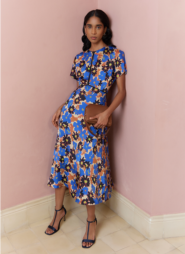 Model photographed blue and beige floral dress.