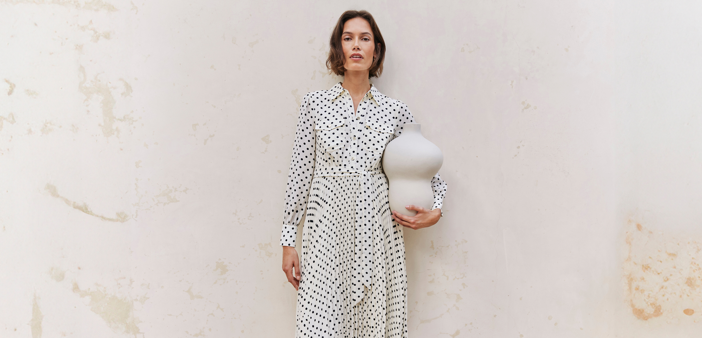 A woman wearing a Hobbs polka dot dress.