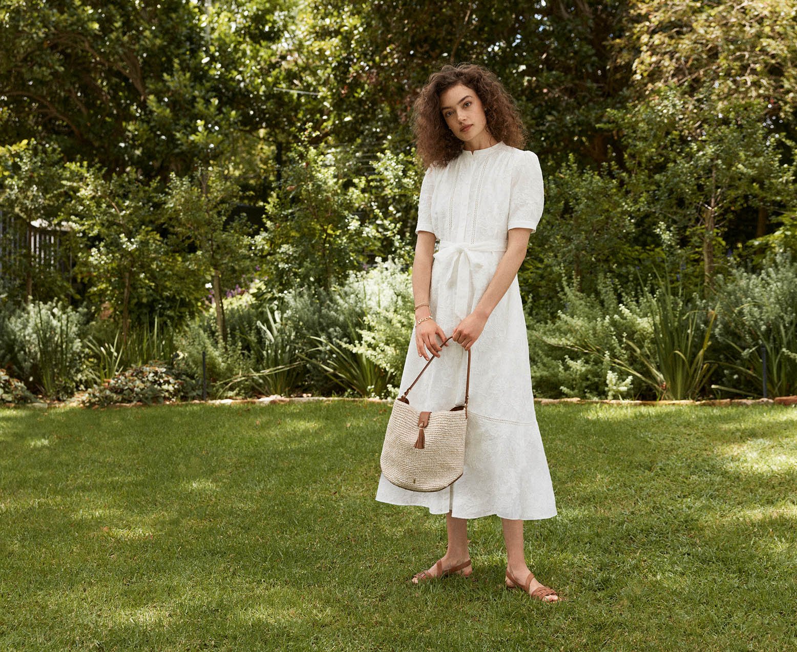 A woman wearing a white Hobbs summer dress.