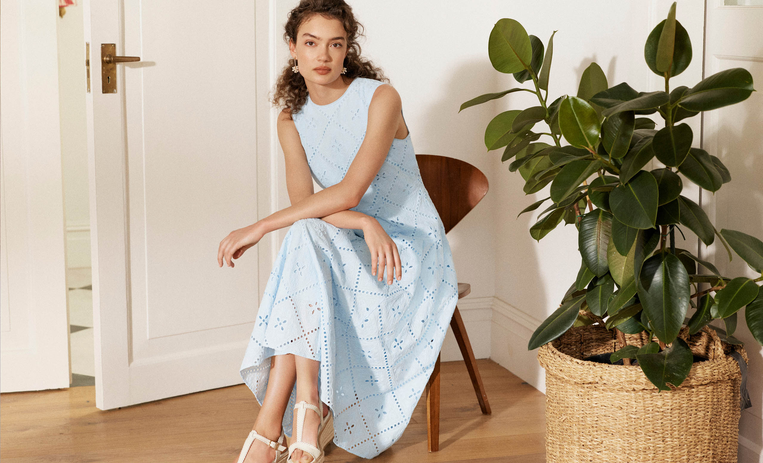 A woman wearing a broderie, petite occasion dress.