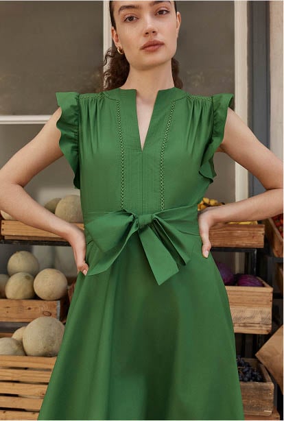 A woman wearing a green Hobbs dress.
