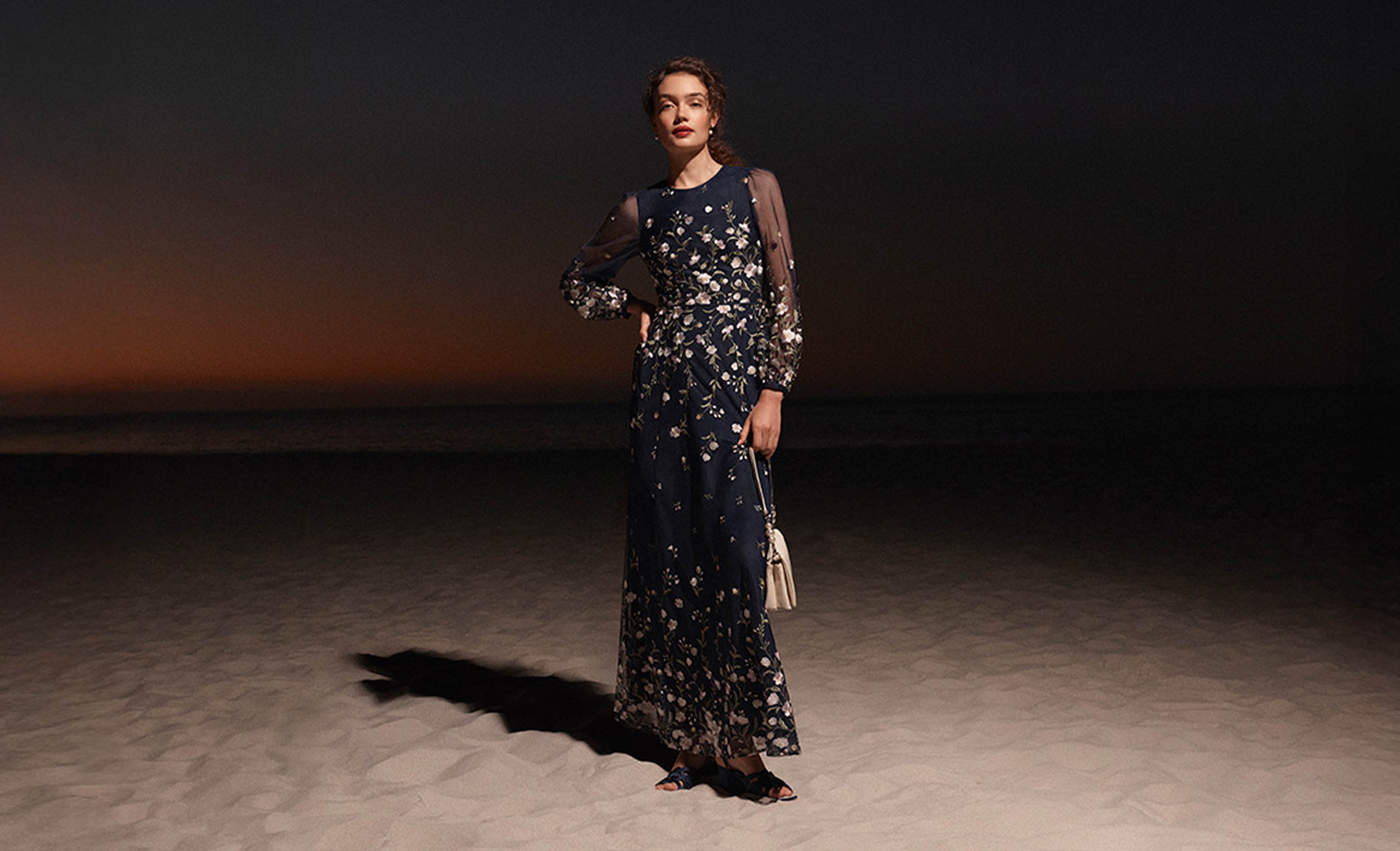 A woman wearing an embroidered Hobbs Black Tie dress.