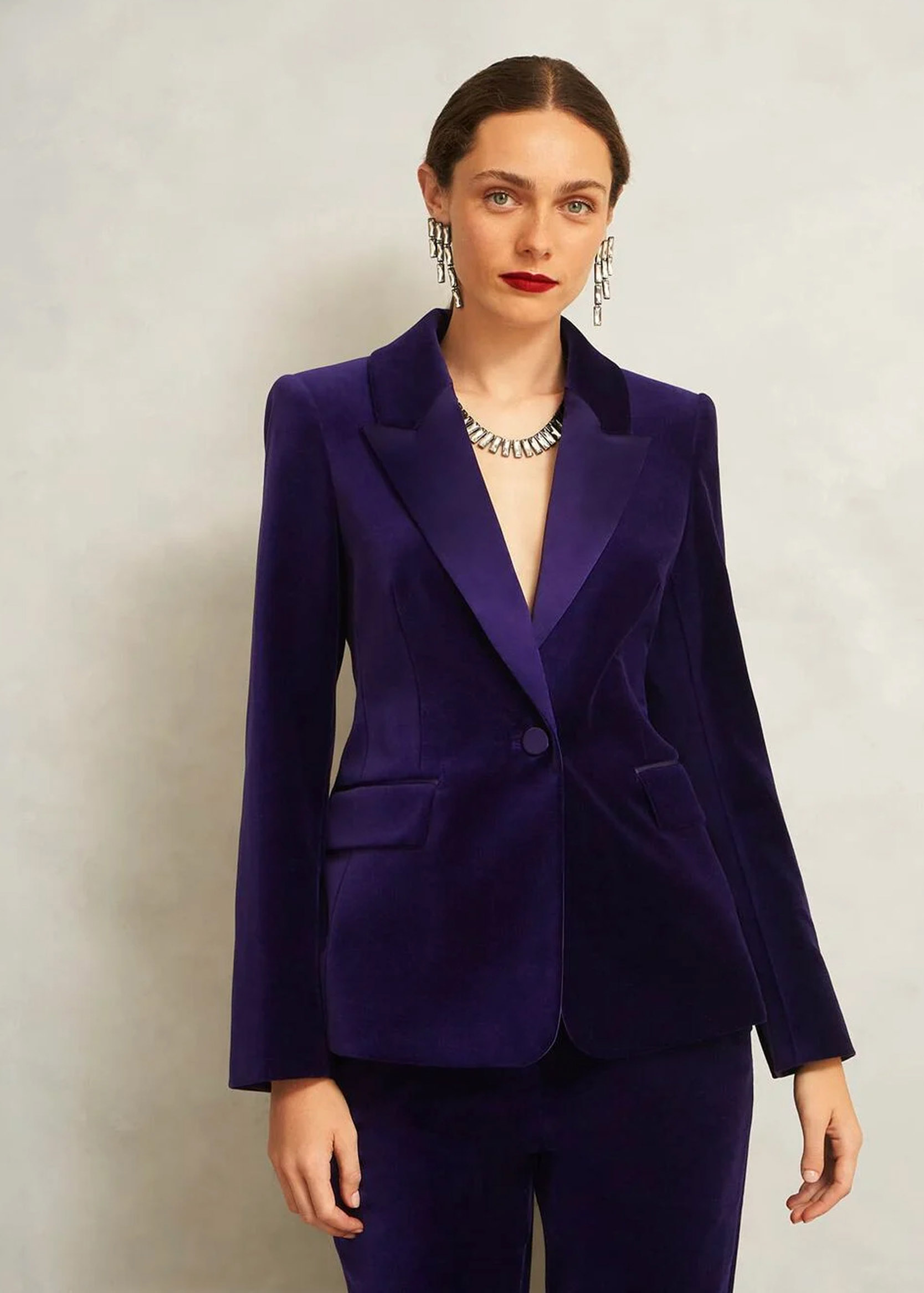A woman wearing a purple velvet suit.