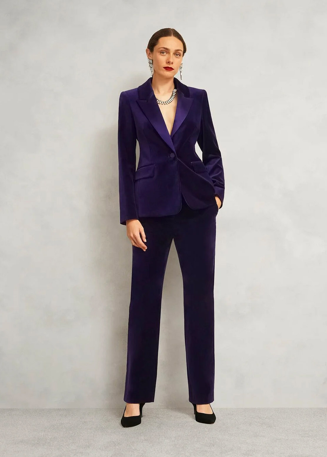 A woman wearing a purple velvet suit.