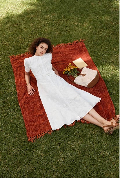 A woman wearing a white Hobbs summer dress.