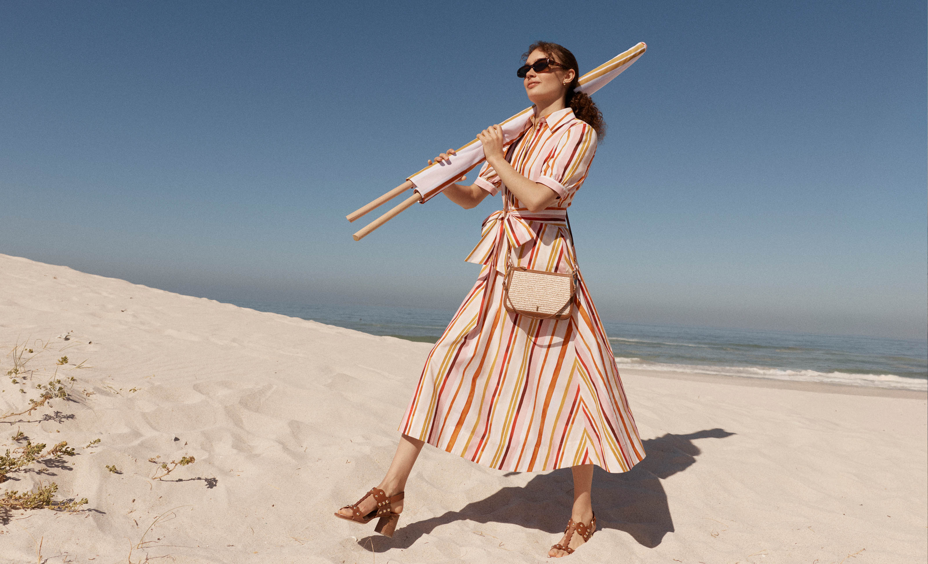A woman wearing a Hobbs striped shirt dress.