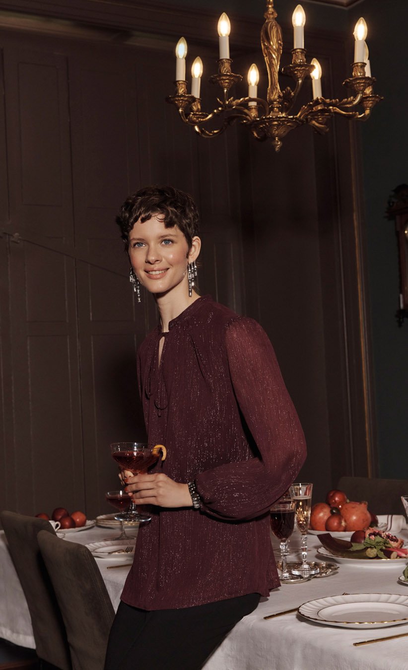 Women wearing chic Christmas party looks in jewel-tone colours.