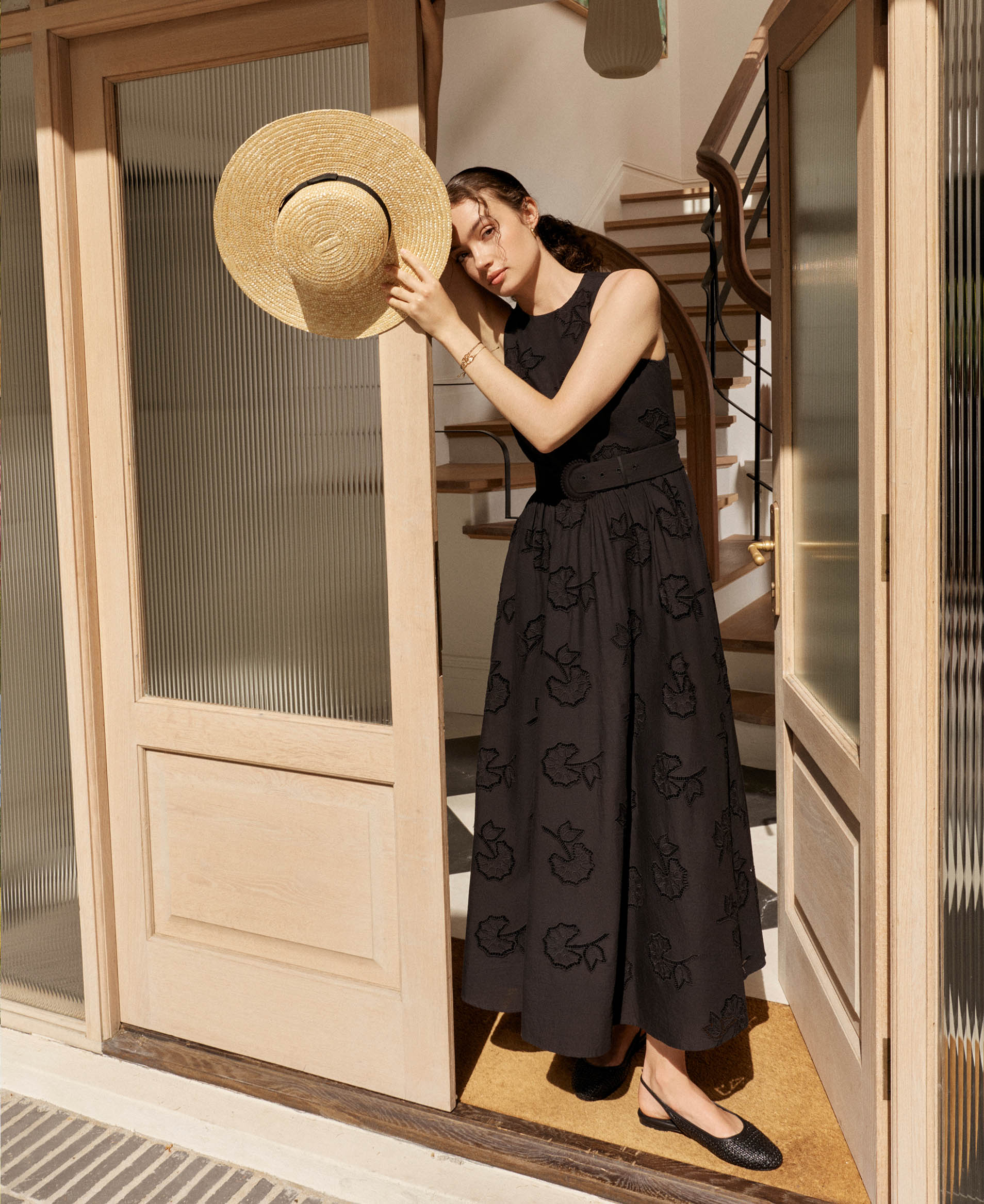 A woman wearing a black, embroidered, maxi dress.