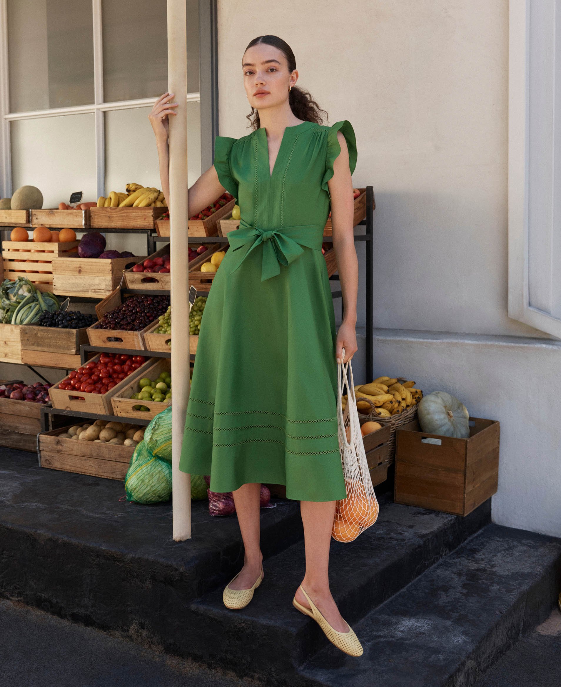 A woman wearing a green Hobbs dress.