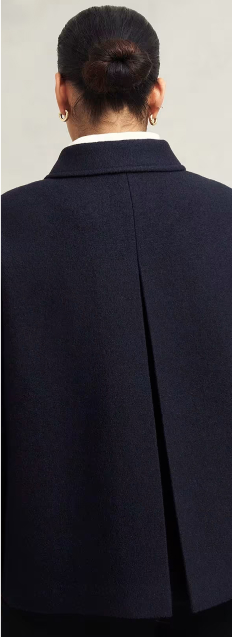 A gallery of four images including one image of a model wearing a navy coat, and three smaller images displaying details of the coat.