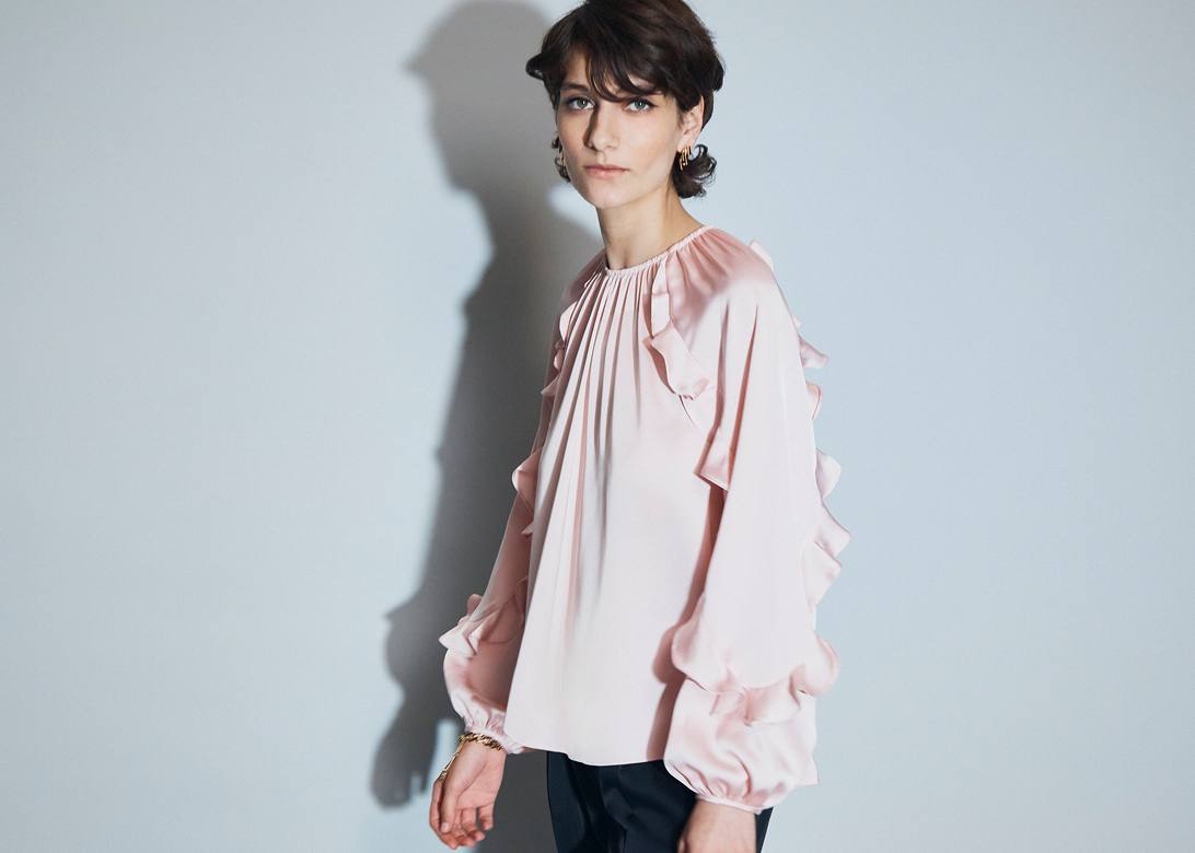 Model photographed in a pink blouse.